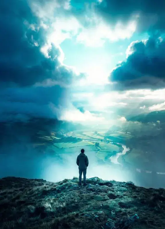 Solitary figure on hilltop with light breaking through clouds for depression therapy