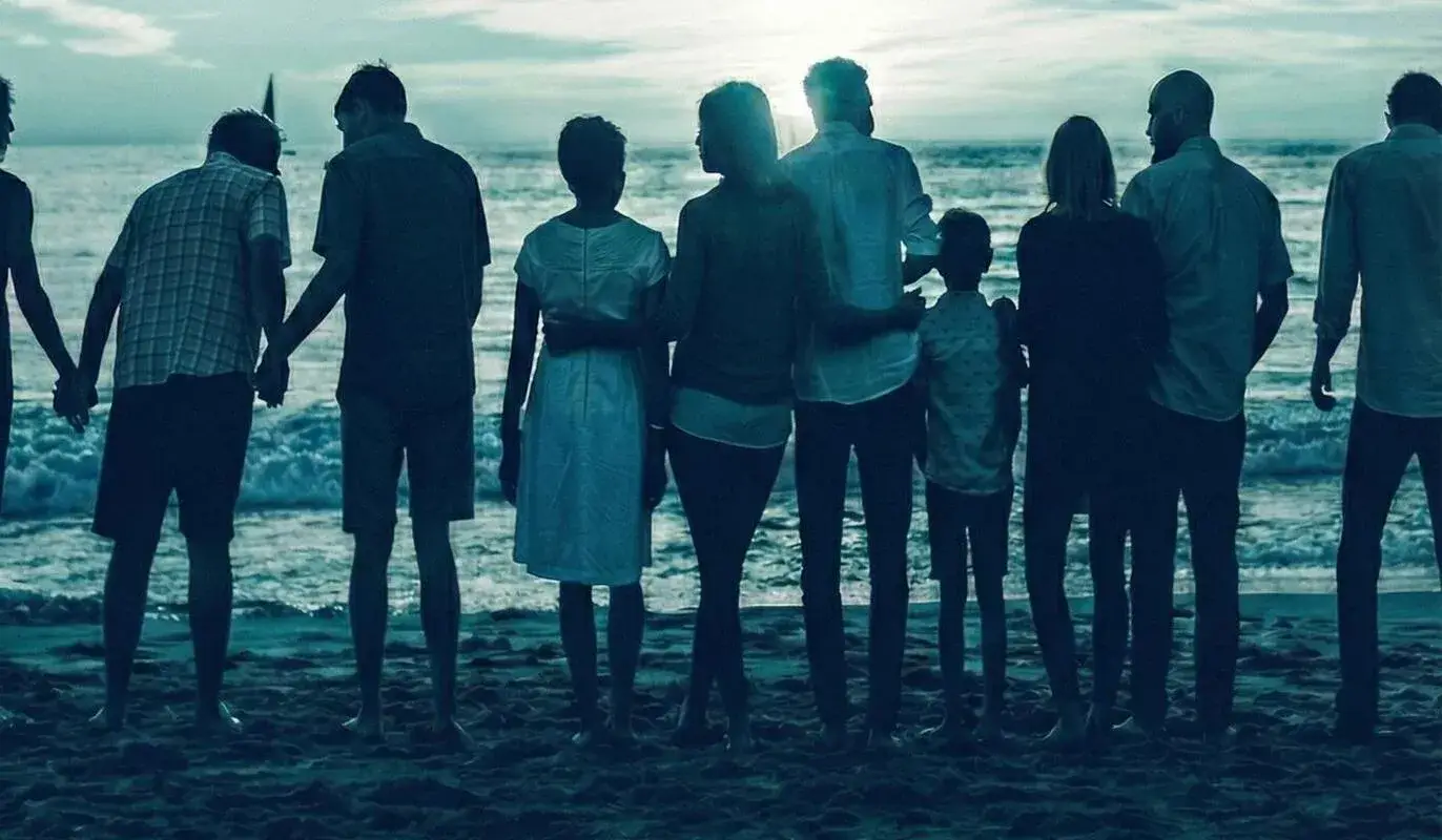 Multi-generational family on beach at sunset for family of origin therapy